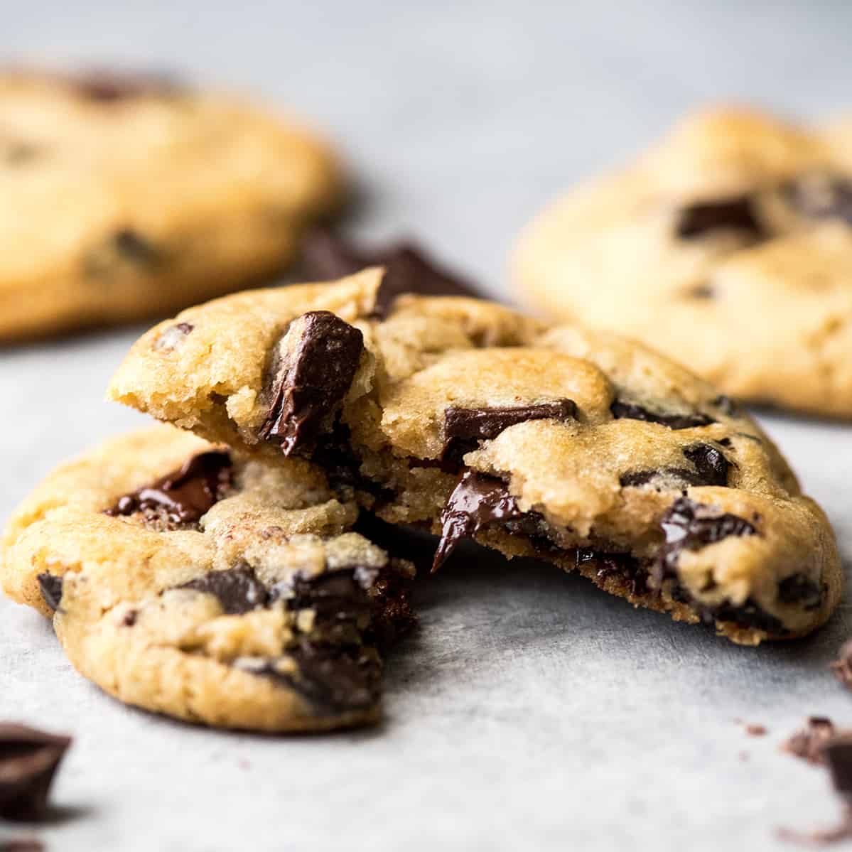 Front view of a chocolate chip cookie cut in half with melty chocolate chips 