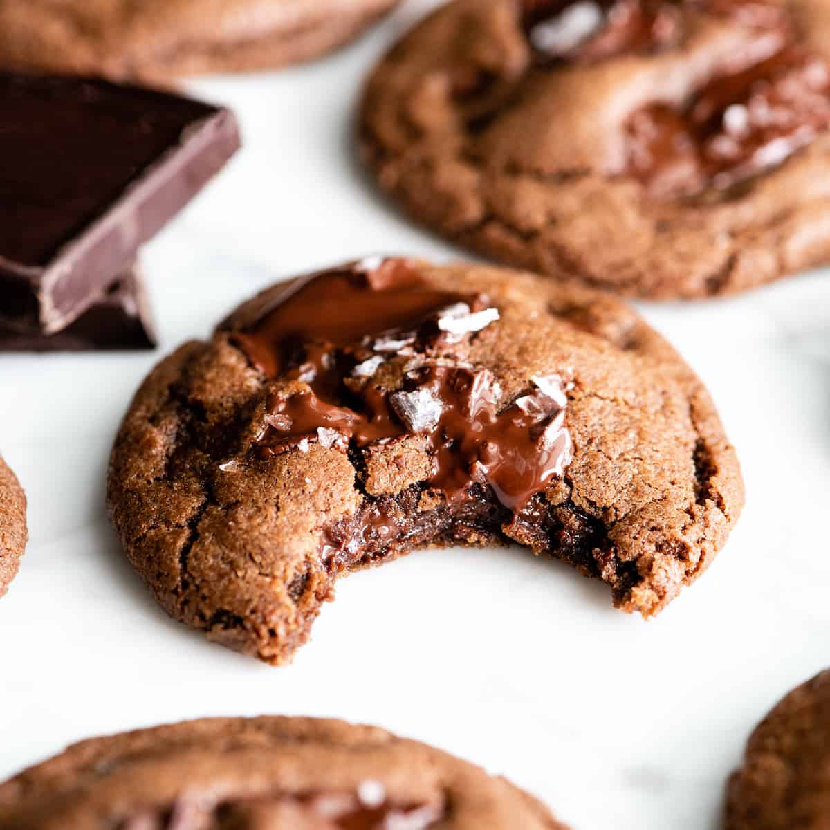 The BEST easy double chocolate chip cookie recipe ever! These chocolate cookies have soft centers, chewy edges and are irresistibly chocolatey. They come together in 5 minutes and require only 30 minutes of chilling time! #chocolate #cookies #chocolatecookies #baking #joyfoodsunshine Front view of a double chocolate cookie with a bite taken out of it