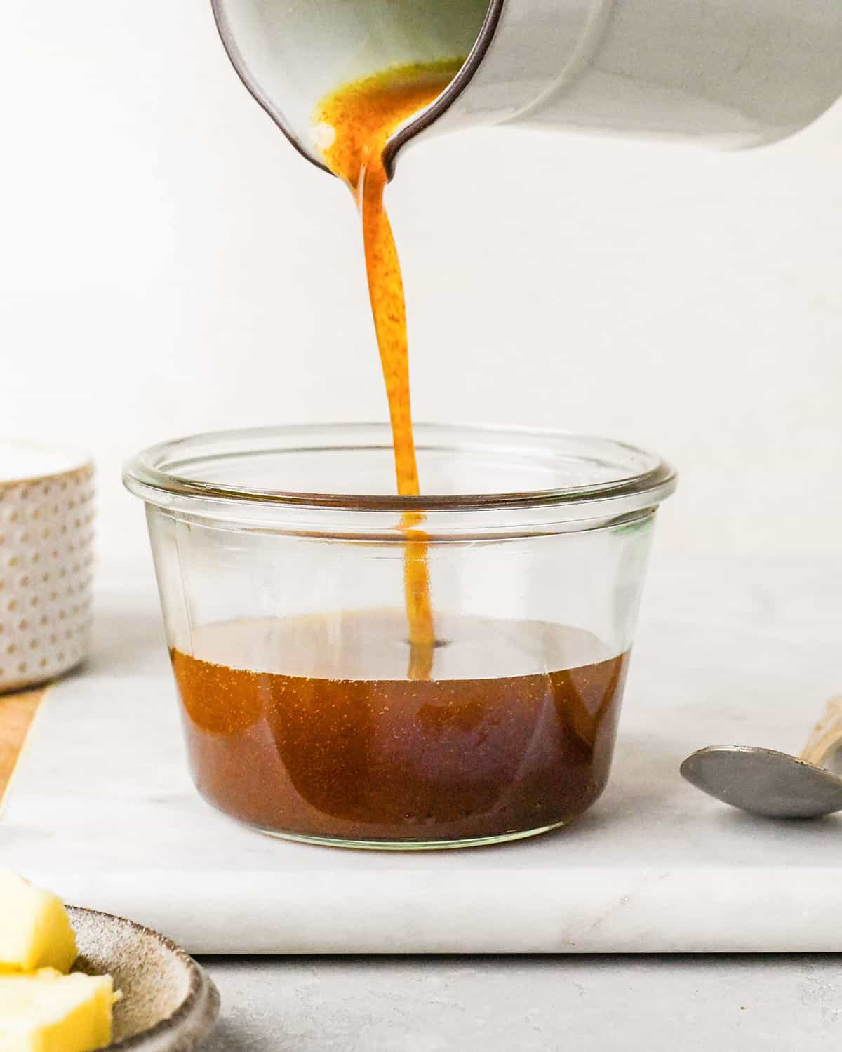 brown butter being poured into a jar